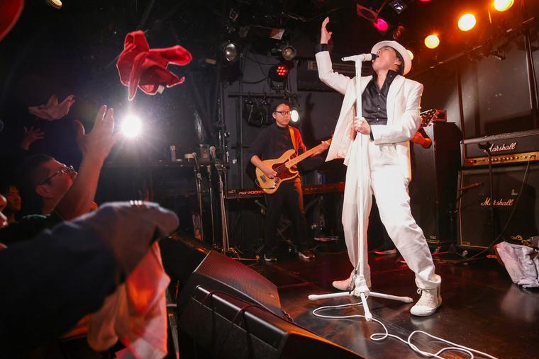 バンドをバックに歌う経営者アーティスト。