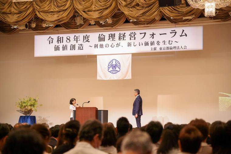 開会。ステージには「価値創造 〜利他の心が、新しい価値を生む〜」の看板。